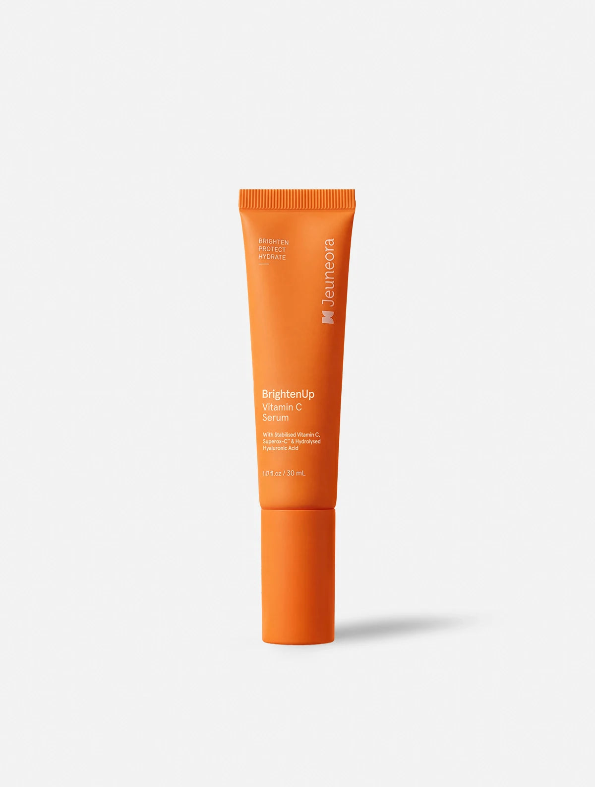 An orange squeeze tube of Jeuneora BrightenUp Vitamin C serum, standing upright against a light gray background with a soft shadow.