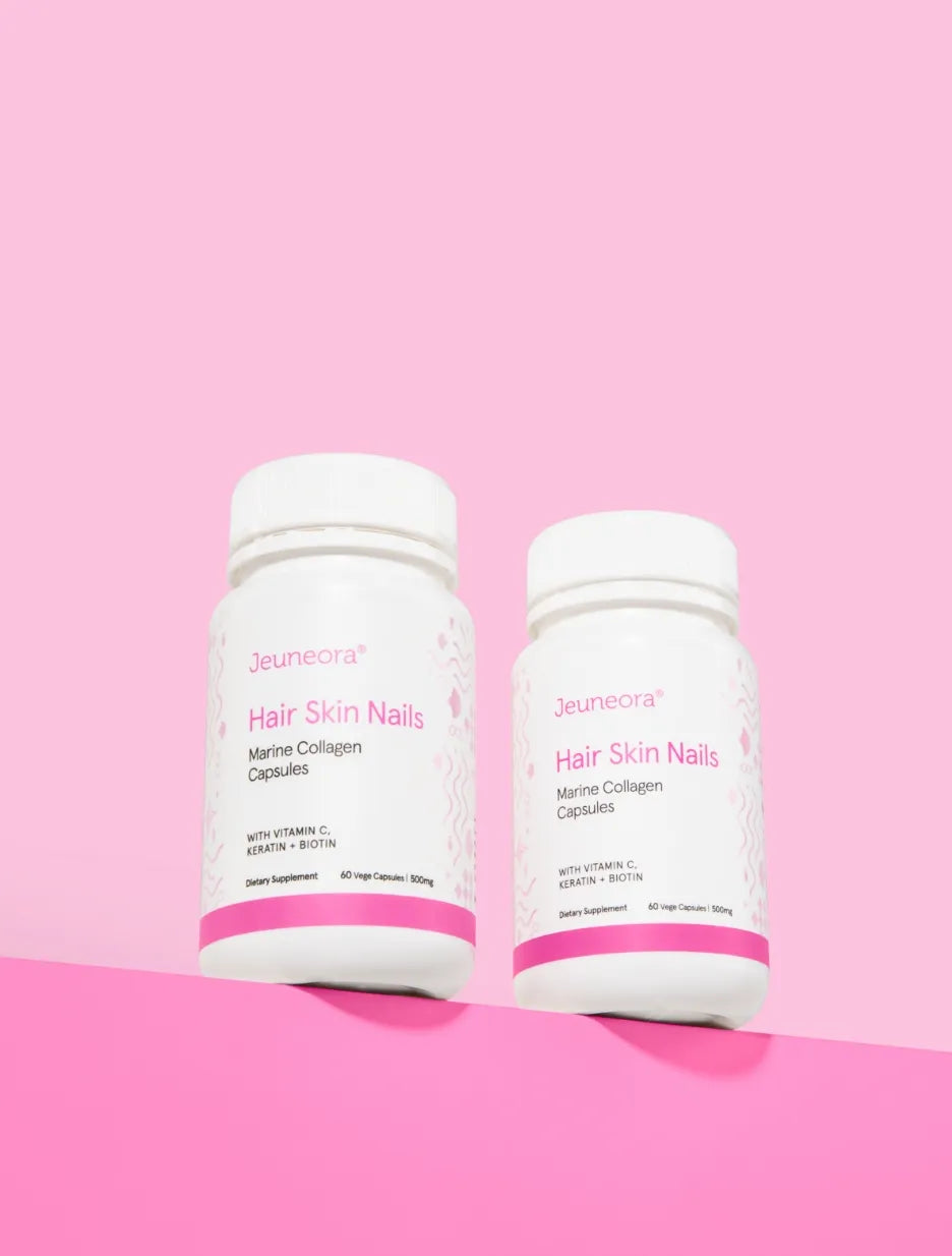 Two Hair Skin Nails capsules containers sit on a shelf in front of a pink background