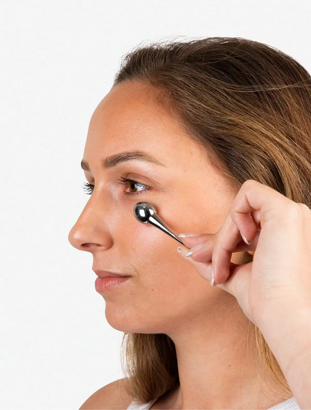 women using cooling eye roller on her eyes