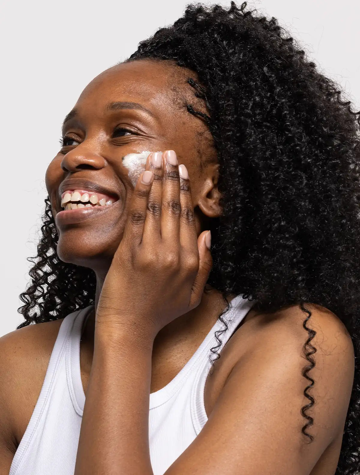 Woman applying suncreen to her cheek