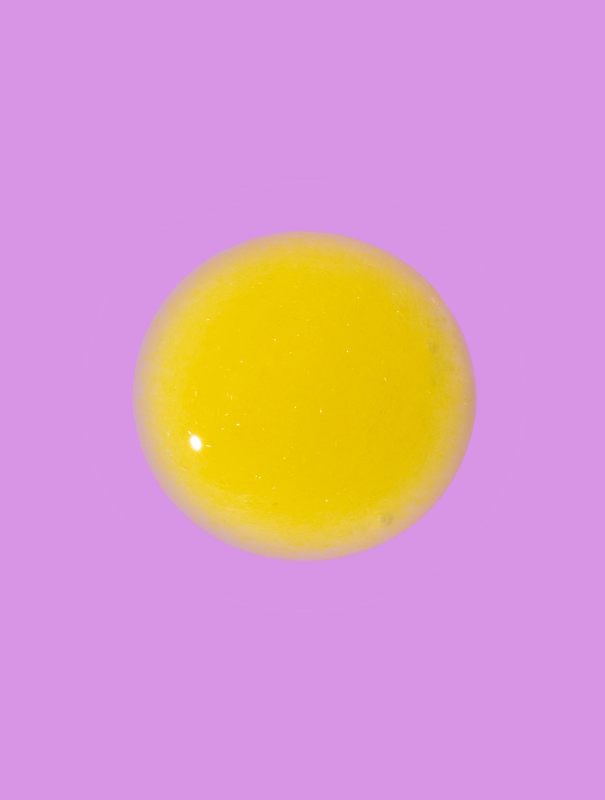 yellow retinol face serum texture on purple background