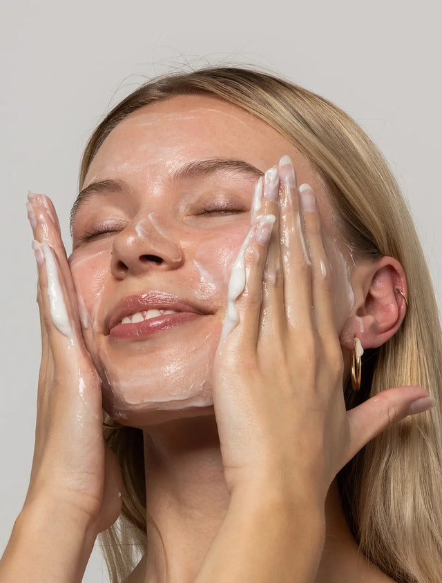 Woman washing face with SoWhippy cream cleanser