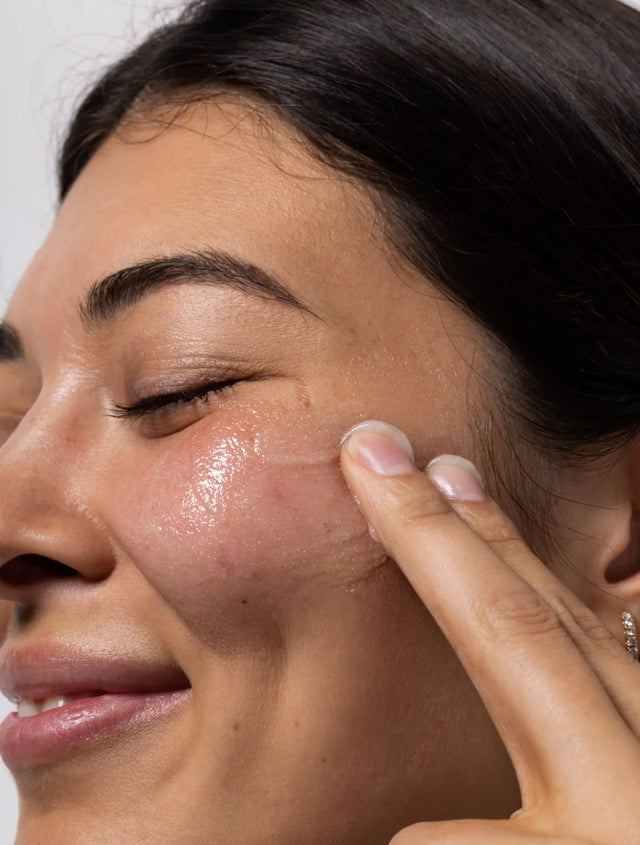 Model applying SupearlaNova Hydrating Face Polish onto her face