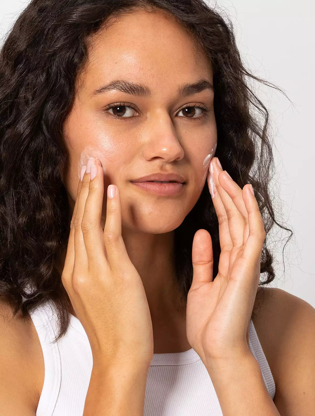 Woman applying Jeuneora GoLightly™ Plump & Protect Day Cream on her face